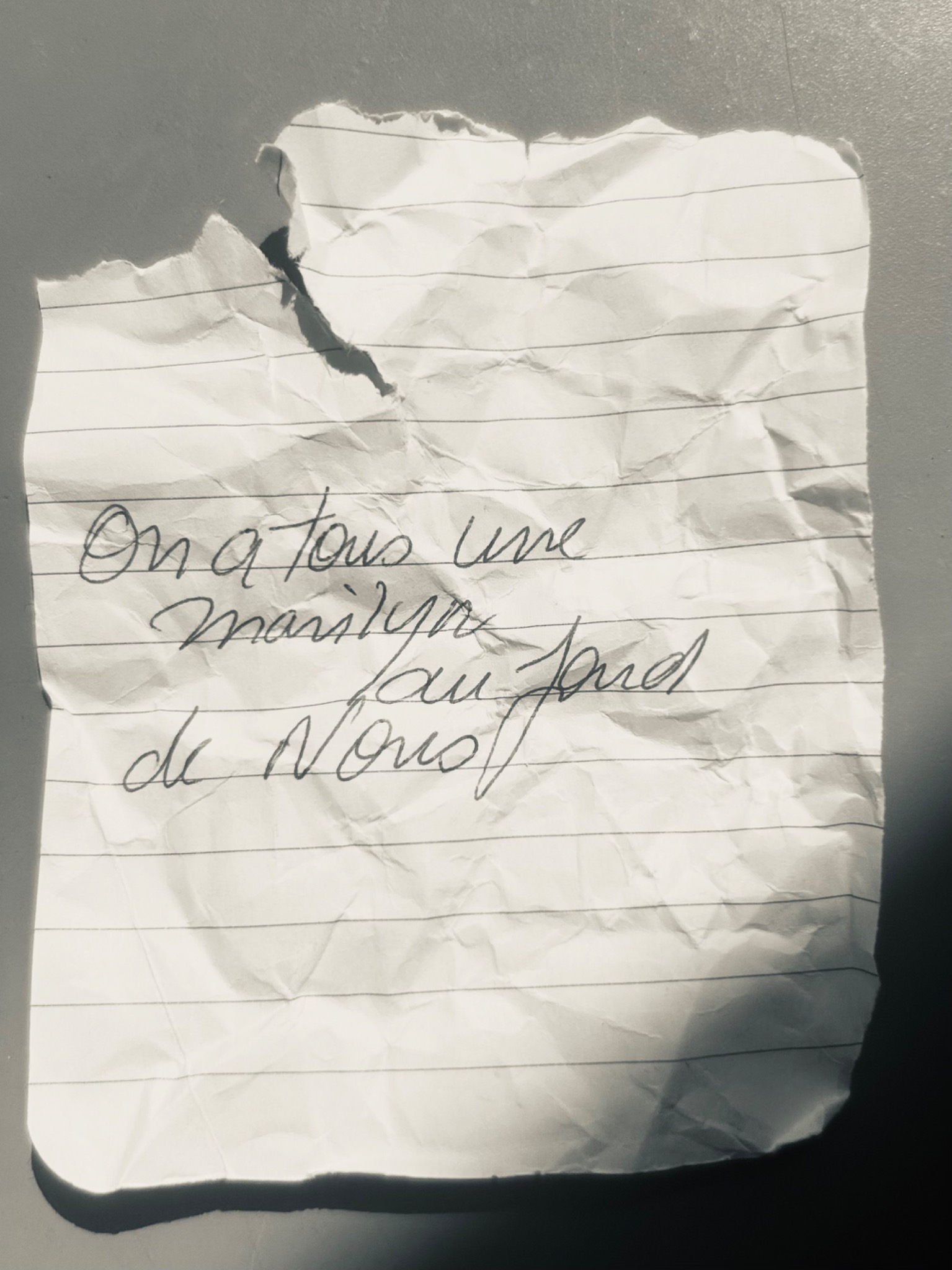 Création artistique autour de Marilyn Monroe — papier froissé portant la phrase manuscrite : On a tous une Marilyn au fond de nous