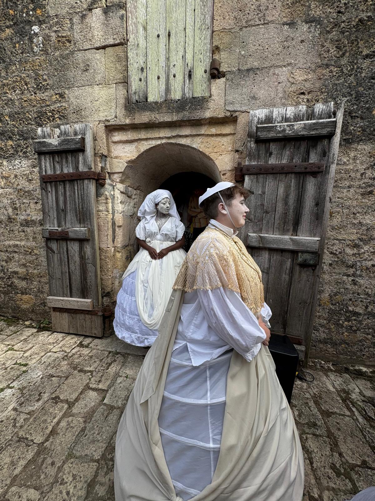 Deux interprètes costumés devant une porte du Fort Médoc